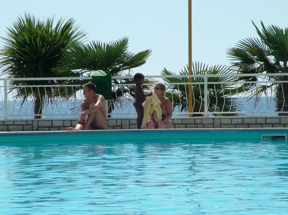 Photo of naturists in an outdoor pool - Pure naturism teaches us to accept ourselves and others without judgment or criticism
